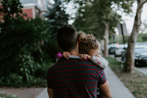 A dad carrying his toddler on a walk